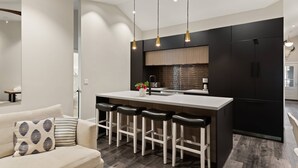 A modern kitchen with a central island, bar stools, and pendant lighting. - 700 Monarch Condos by iTrip Aspen Snowmass (Aspen)