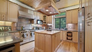 A spacious kitchen with wooden cabinets, stainless steel appliances, and a central island.