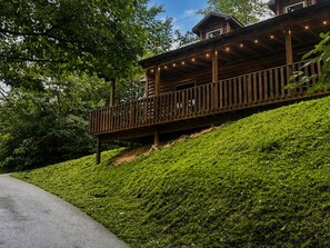 Une cabane en bois dotée d’un balcon, entourée d’une végétation luxuriante.