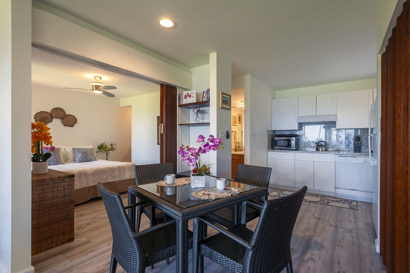 A compact living space with a dining area, kitchenette, and a bedroom.