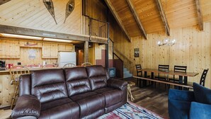 A wooden cabin interior with a leather sofa, dining table, and chairs. - Close to Wolf Creek, Fish San Juan River, Escape the Crowds (Pagosa Springs)