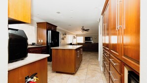 A kitchen with wooden cabinets, a central island, and a ceiling fan.