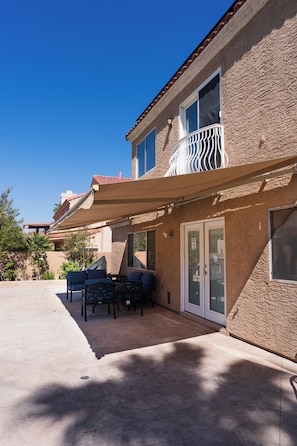Un bâtiment doté d’un patio couvert, d’un balcon et d’une porte avec un panneau de verre.