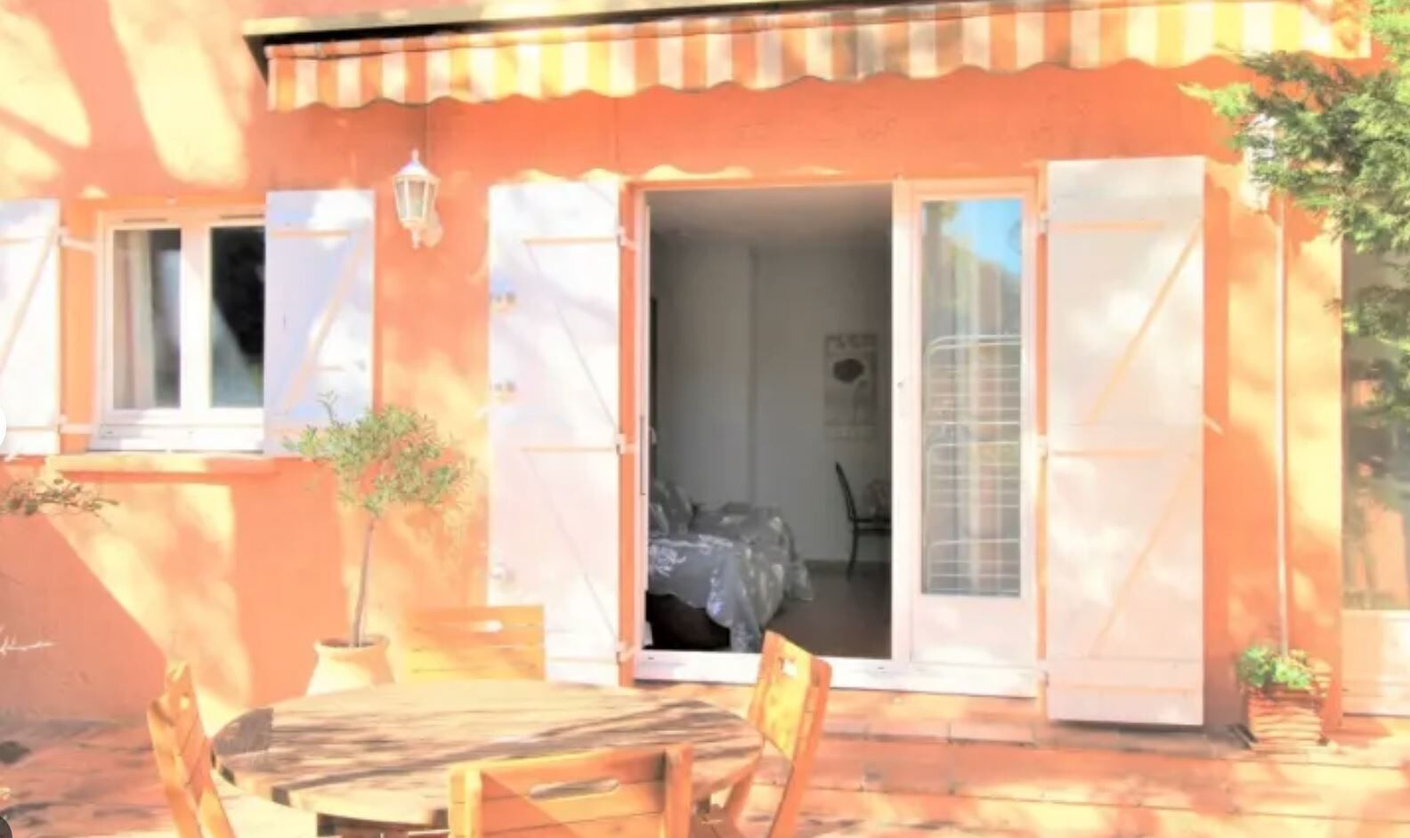A house with a patio, a table, and chairs.