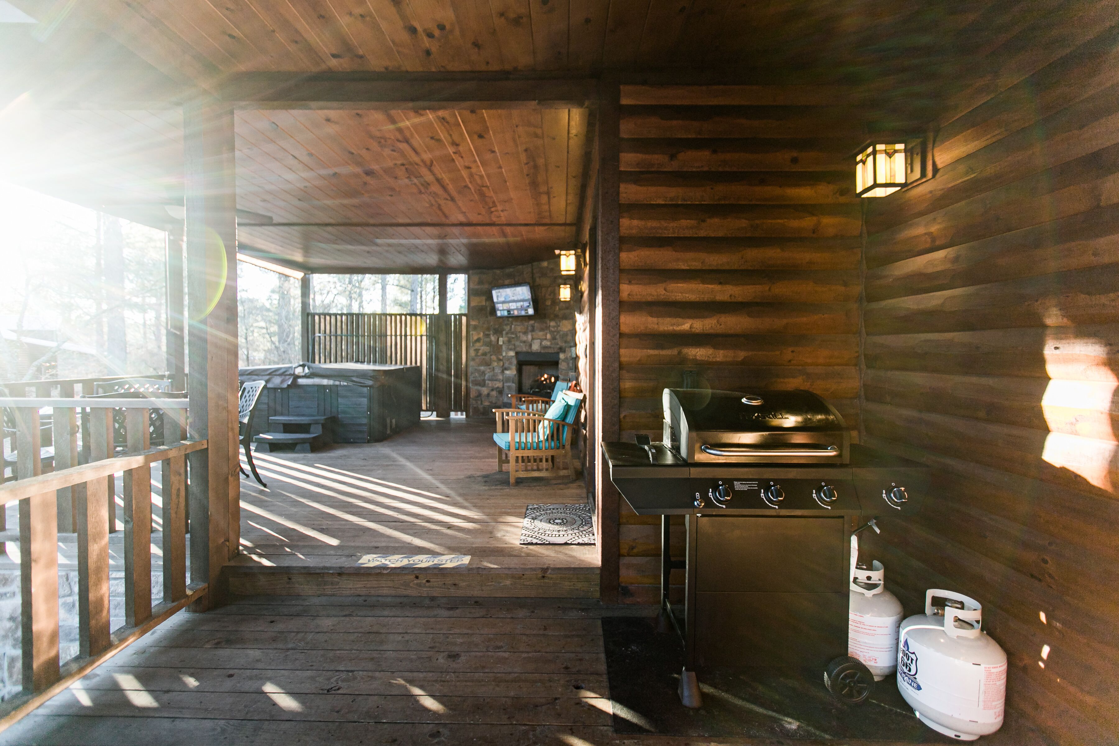 Een houten chalet van binnen met een open haard, een grill en propaanflessen.