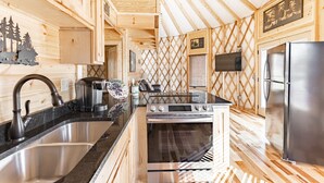 A modern kitchen with a stainless steel sink, a stove, and a refrigerator. - Luxury Yurt Cozy & Fun 1br/1bth, experience it, Private Deck w Grill & HotTub (Pigeon Forge)