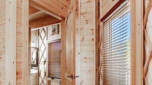 A wooden interior with a wooden floor, a window with blinds, and a door leading to another room. - Luxury Yurt Cozy & Fun 1br/1bth, experience it, Private Deck w Grill & HotTub (Pigeon Forge)