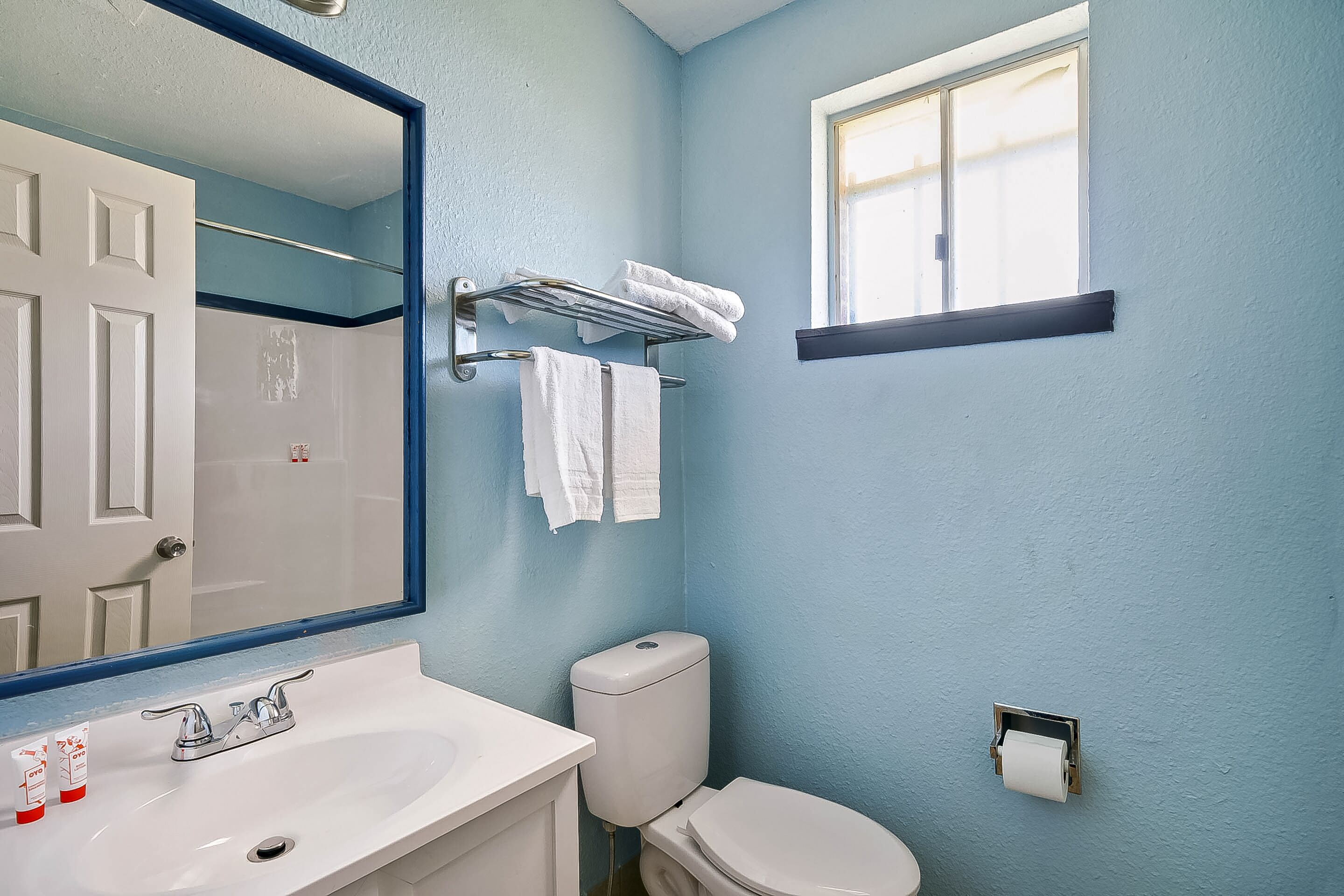 A bathroom with a sink, toilet, and a towel rack.