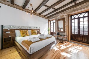 A bedroom with a wooden bed, a nightstand, a desk, and a large window with a view. - GuestReady - CastleRock Live Music Pub - 1F (Porto)