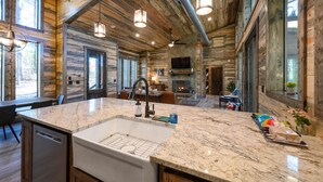 A spacious kitchen with a large island, granite countertops, and a built-in dishwasher. - Modern and Luxury Cabin, 2 BR 2.5 Bath, Sleeps 9 max, 2 Pets Max with Pet Fee (Broken Bow)