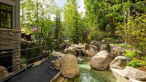 A spa area with a hot tub, large rocks, and a waterfall. - Aspenwood by iTrip Aspen Snowmass (Snowmass Village)