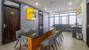 A modern kitchen with a central island, grey chairs, and a large window. - Richy Hotel (Da Lat)