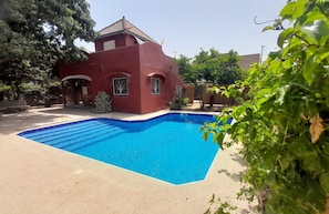 A swimming pool with a red building in the background.
