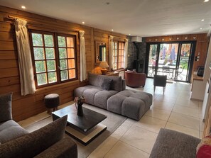 A cozy living room with a sectional sofa, a coffee table, and a fireplace.