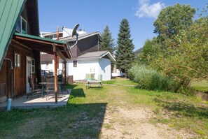A house with a covered patio, a barbecue area, and a small garden. - CJ A-Frame 2 - In Town - Ski In/Ski Out - On The River - Free WiFi (Red River)