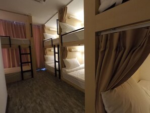 A bunk bed room with a wooden floor, a ladder, and curtains. - Signel Hostel (Kota Kinabalu)