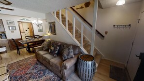 Un salon avec un canapé, une table à manger et un escalier.