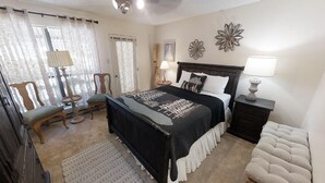 Une chambre à coucher avec un lit, des tables de chevet, une chaise et une lampe.