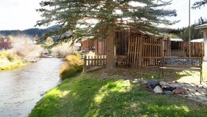 A riverside walkway with a wooden fence, a bench, and a small building with a sloped roof. - By the River - In Town - On The River - Backyard Fishing Spot - Free WiFi - Cabl (Red River)