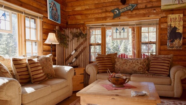 A cozy log cabin interior with two sofas, a coffee table, and a staircase. - Dwyer's Den - Upper Valley - Rustic Interior and Decor - Near The River - Satell (Red River)