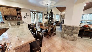 A spacious kitchen with a marble countertop, wooden cabinets, and a stone accent wall.