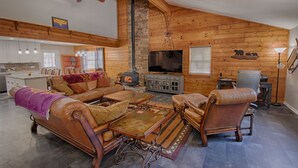 A cozy living room with a fireplace, leather sofas, and a television. - Mountain Living at its Finest! (Pinetop)