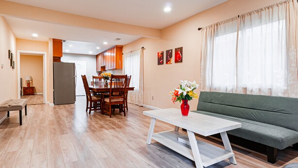A spacious living area with a dining table, chairs, a sofa, and a coffee table.