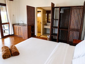 Una habitación de hotel con cama, baño y kitchenette.