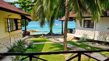 A tropical resort with a pool, palm trees, and a view of the ocean.