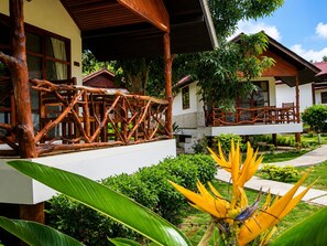 Un resort con estructuras de madera, un paseo techado y abundante vegetación.
