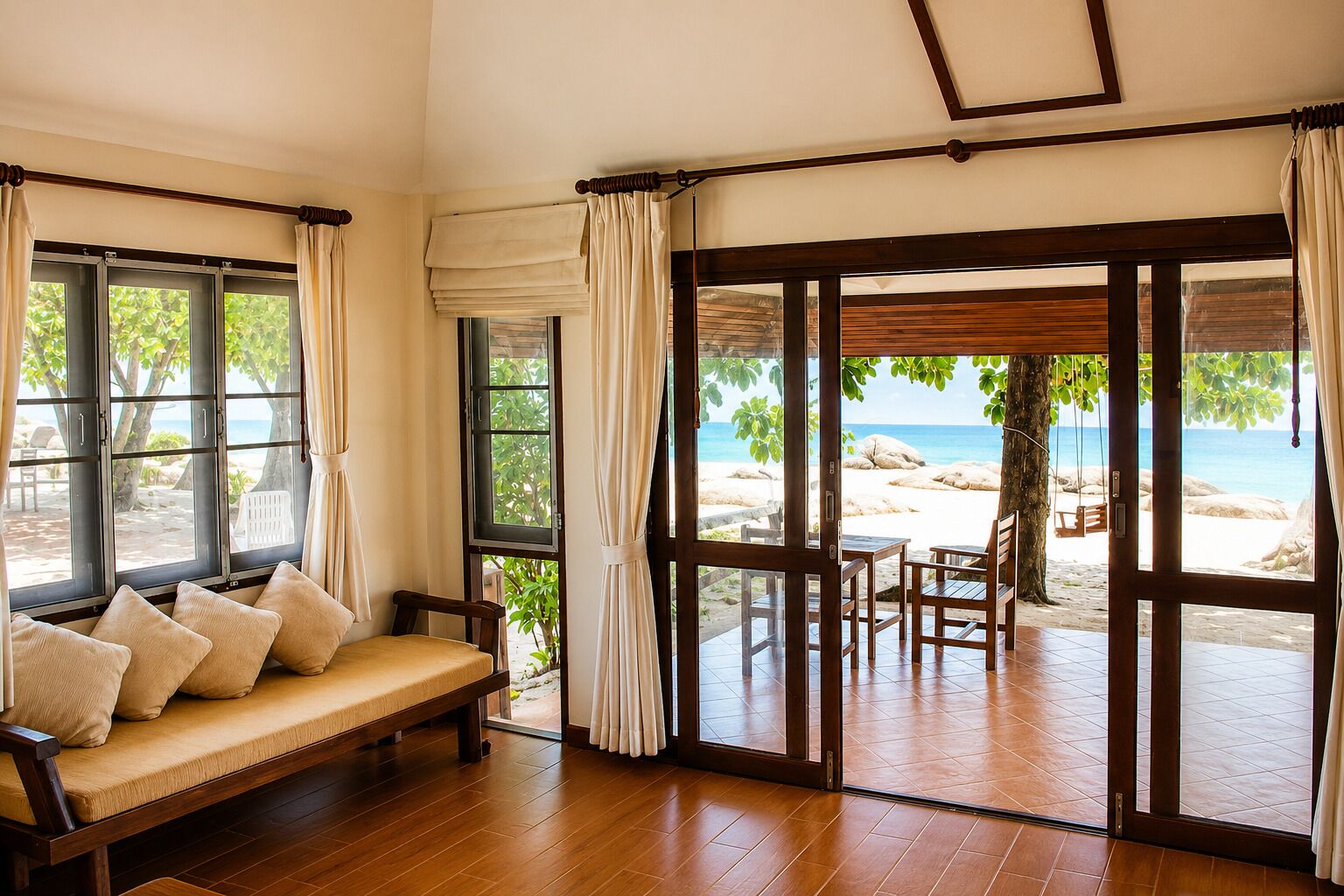 A room with a wooden bench and a view of a beach through large glass doors.