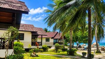 A beachfront property with a two-story building, a covered patio, and a view of the ocean.