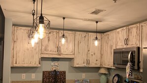 Eine Küche mit Holzausstattung, einer Granit-Arbeitsplatte, einem Backofen, einer Mikrowelle und einem Geschirrspüler.