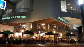 Ett Starbucks-kafé med uteservering och parasoller.