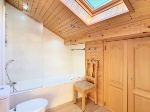Bathtub, hair dryer, towels, toilet paper