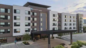 A multi-story hotel with a prominent 'HYATT house' sign, a covered entrance, and a parking lot. - Hyatt House Columbus OSU / Short North (Columbus)