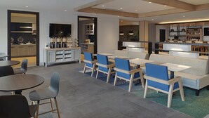 A modern hotel lobby with a bar area, seating arrangements, and a television. - Hyatt House Columbus OSU / Short North (Columbus)