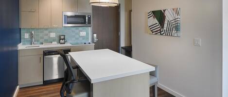 Una cocina moderna equipada con microondas, cafetera y lavavajillas.