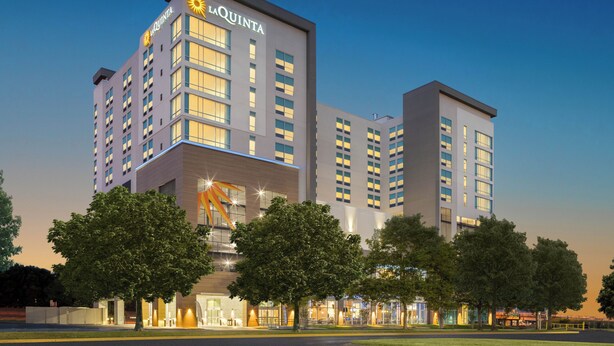 A hotel with multiple floors, a prominent sign, and a well-lit entrance.