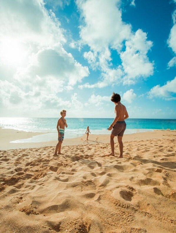 A beach with three people standing on the sand, a clear sky, and the ocean in the background. - avid hotel Corpus Christi - Portland by IHG (Portland)
