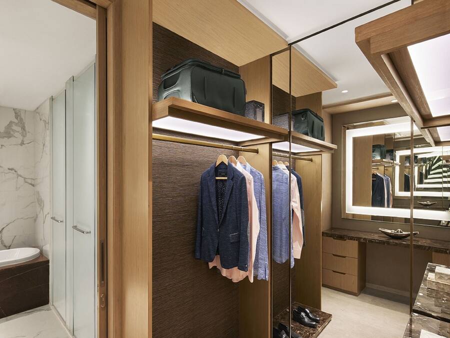 Un vestidor moderno con estantes de madera, un espejo y un zapatero.