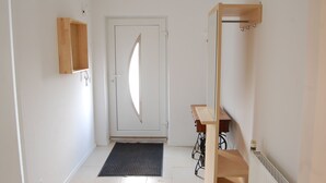 A hallway with a white door, a wooden cabinet, a radiator, and a radiator cover. - Wohnung mit Kamin Terrasse und Grill in der Nähe von Nürnberg (Burgthann)