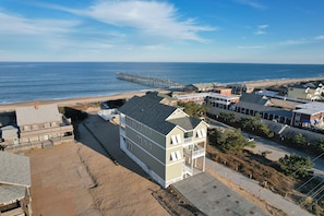 A coastal building with a flat roof, multiple windows, and a balcony. - 5450- Wench's Pad 3, Spacious Oceanfront Nags Head Home with Private Pool! (Nags Head)