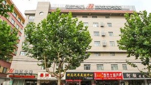 Un immeuble à plusieurs étages, avec une enseigne « Jinjiang Inn » au sommet.
