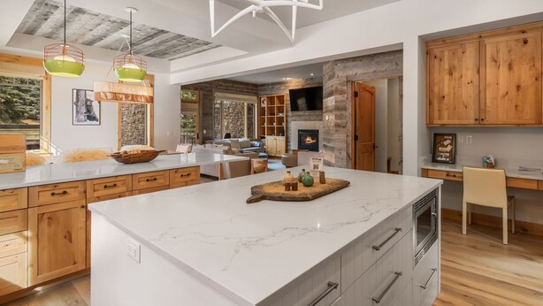 Une cuisine moderne dotée d’un grand îlot central, de meubles en bois et d’une cheminée en pierre.
