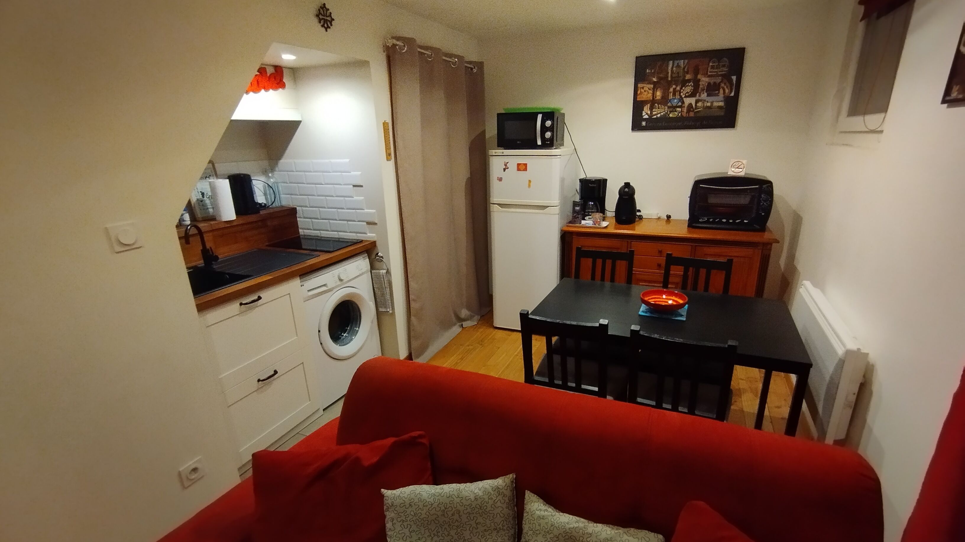 Una cocina compacta equipada con lavadora, microondas y cafetera.