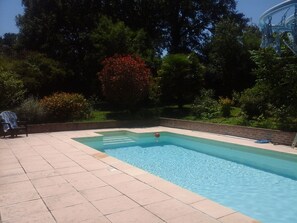 Une piscine rectangulaire avec une zone de plage carrelée.