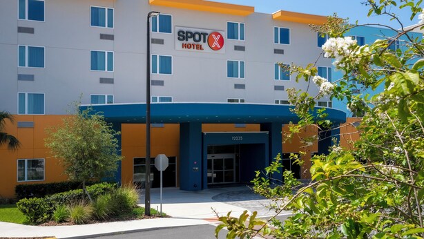 A modern hotel with a sign reading "SPOT X HOTEL" and the number "12235" on the entrance. - SPOT X Hotel Orlando/Intl Dr by The Red Collection (Orlando)