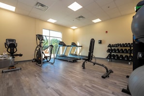 A gym with treadmills, a stationary bike, and a rowing machine. - SPOT X Hotel Orlando/Intl Dr by The Red Collection (Orlando)