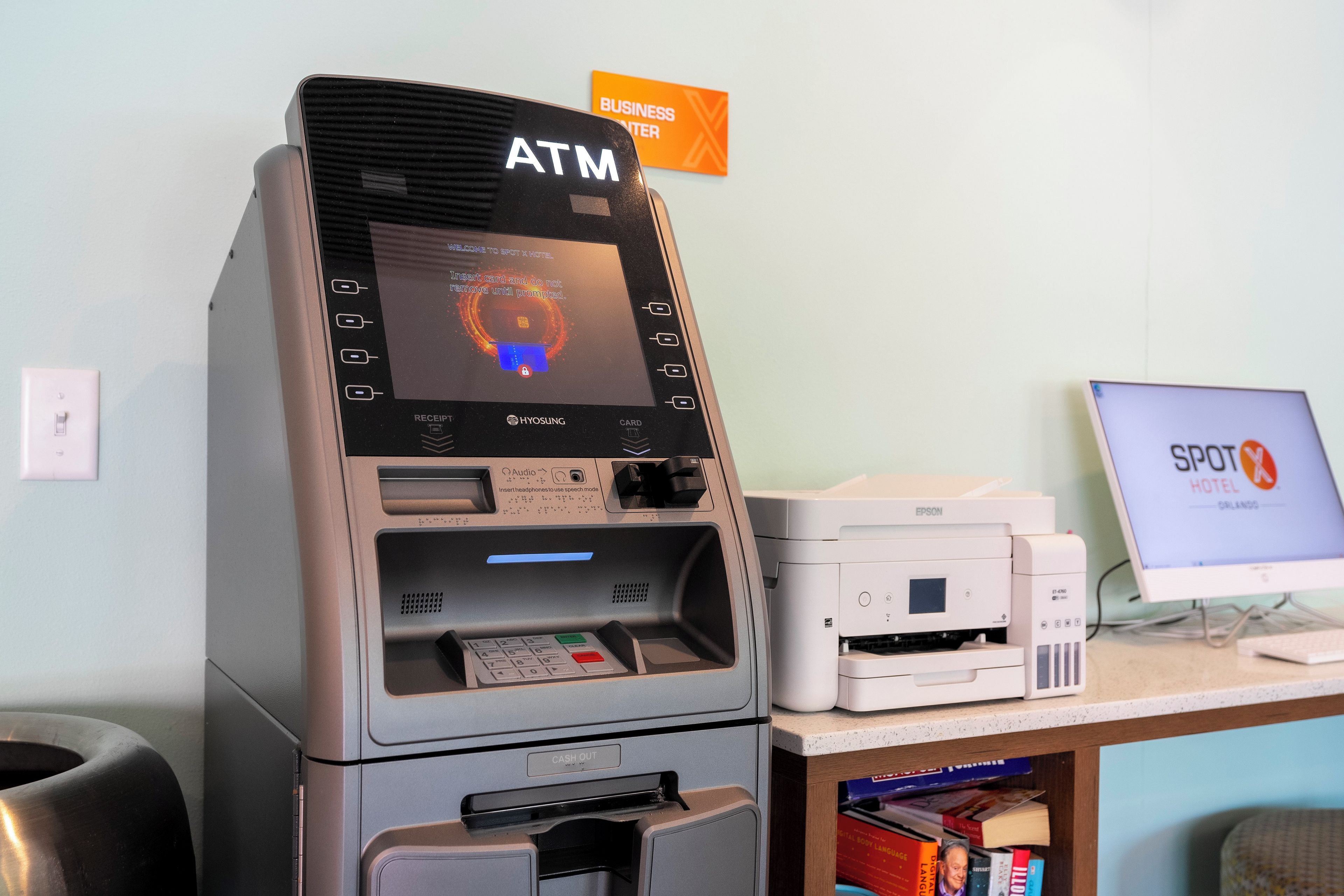 Um caixa automático com abertura para recibos, dispensador de dinheiro e leitor de cartão.